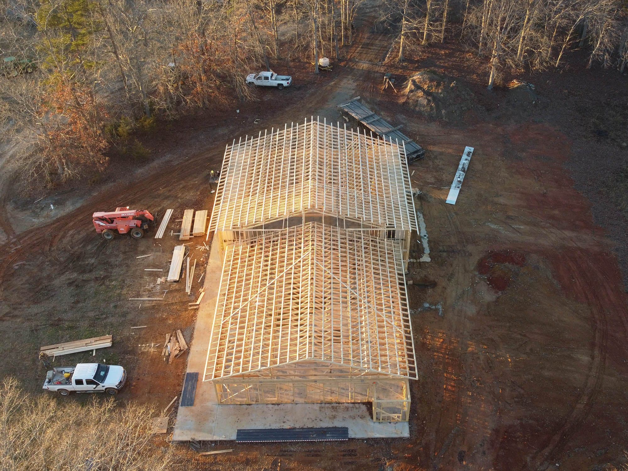 Aerial view of a timber-framed building under construction with roof framing visible, South Boston, Virginia