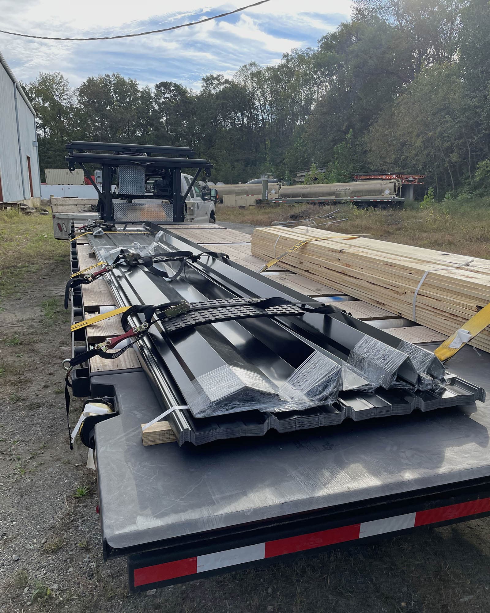 Flatbed truck loaded with metal roofing panels and framing lumber, strapped down, at the South Boston, Virginia mill