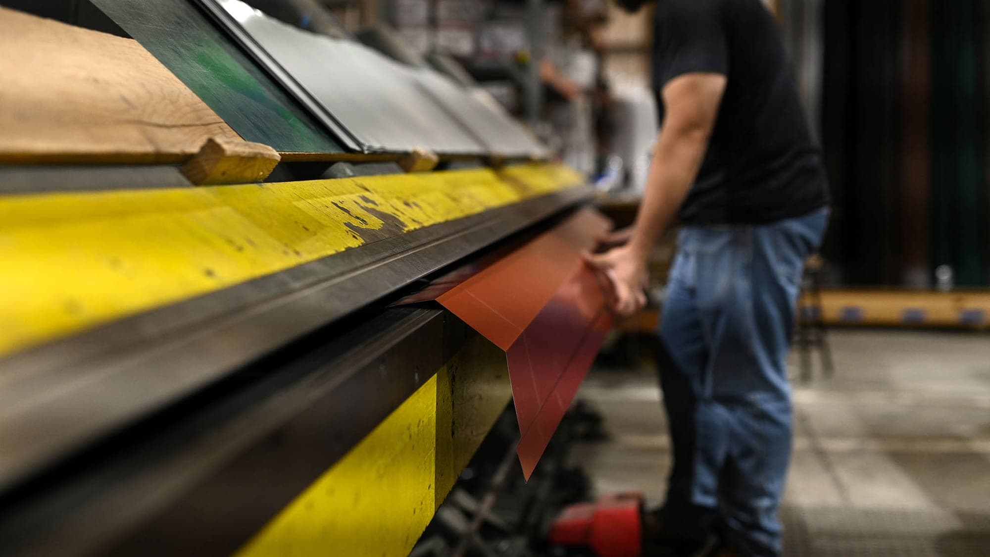 Operator bending red metal trim at the brake at the South Boston, Virginia mill